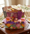 He Gives Strength to the Weary Wonderful Spa Gift Set with gold shimmer mist, body lotion, soy candle, bath bomb, inspirational card and golden butterfly in vibrant floral gift tray with silk gerbera daisies and purple crinkle paper